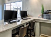 Thumbnail 10 of 24 - Ingleside Apartments Business Center with two computer screens and grey granite countertops and printer
