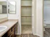 Thumbnail 19 of 24 - Ingleside Apartments Bathroom  with brown cabinets, beige counter tops and large walk in closet