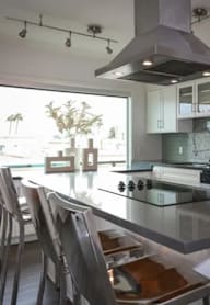 A modern kitchen with a stainless steel refrigerator and a glass island.