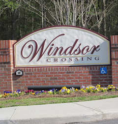 a sign for windsor crossing in front of a building