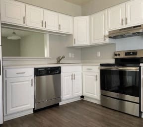 a kitchen with stainless steel appliances and white cabinets at Colony Townhomes, North Carolina, 27609