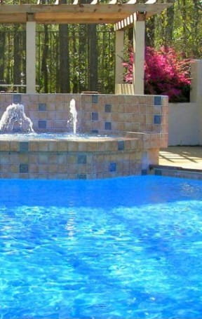 a large swimming pool with a fountain in the middle