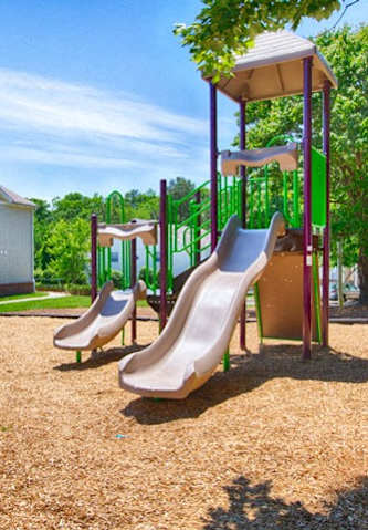 A playground with a slide and a play structure.