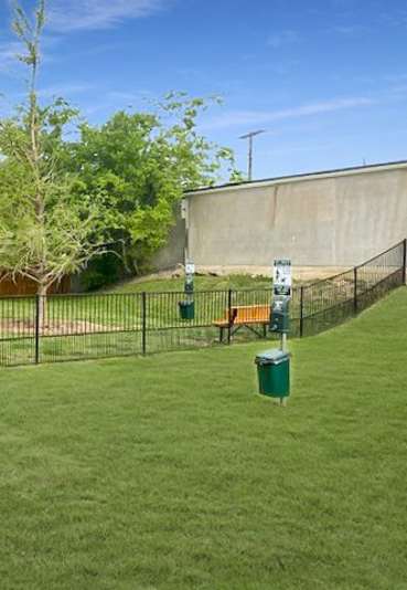 A baseball field with a fence and a tree in the middle.