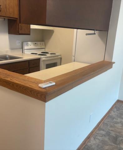 A kitchen with a white counter and brown cabinets.