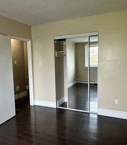 an empty living room with a sliding glass door to a bedroom