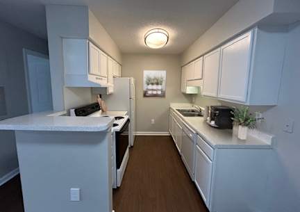 A kitchen with white cabinets and appliances.