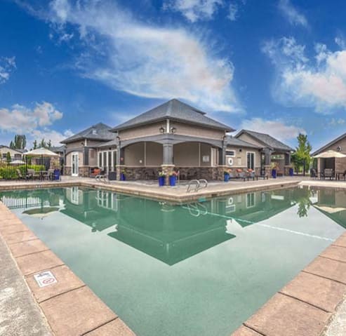 a large swimming pool with a house in the background at BELLA SONOMA, Fife, WA