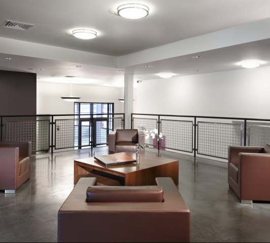 A modern waiting room with brown furniture and a glass door.