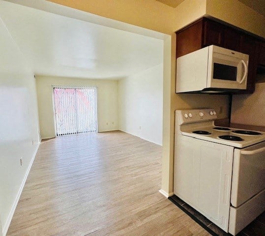 an empty kitchen with a stove and a microwave
