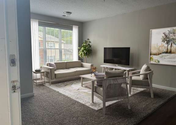 A living room with a couch, chair, and television.