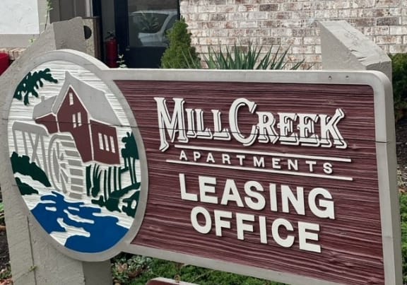 a sign apartments leasing office in front of a building