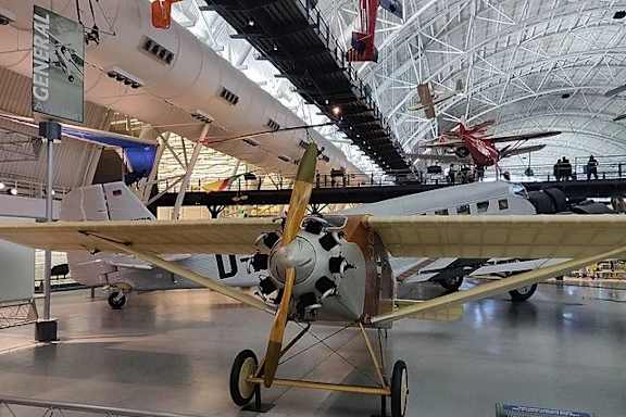 A plane with a cowhide pattern on the side is on display in a museum.