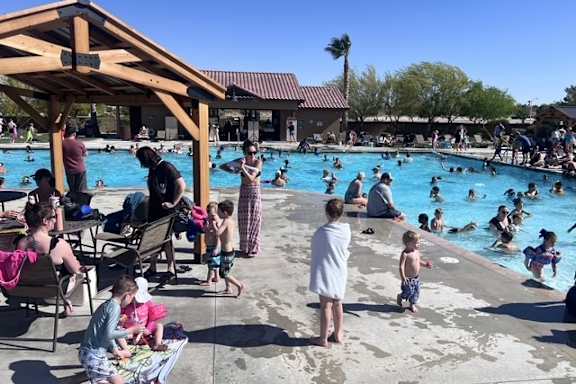 A group of people are enjoying a sunny day at the pool.