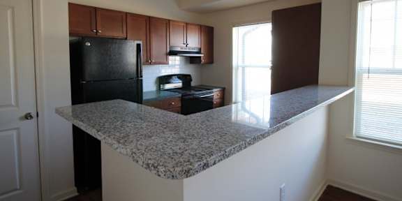 an empty kitchen with a granite counter top