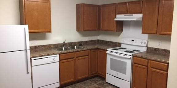 a kitchen with wooden cabinets and white appliances