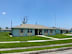 A blue house with a white roof and a white fence in front of it.