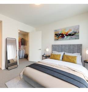 A bedroom with a large bed and a painting on the wall.at Prizma, Los Angeles, CA 90038