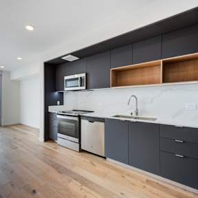 A modern kitchen with a large window overlooking a cityscape.at Prizma, Los Angeles, CA 90038