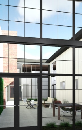 a courtyard with large glass windows and a table and chairs at American Spinning Mill, South Carolina 29609