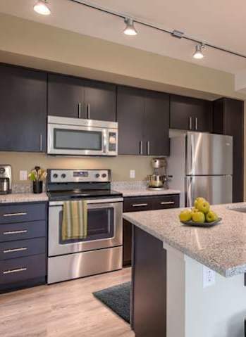 A kitchen with a stove, refrigerator, and microwave. at Kirkland Crossing Apartments, Kirkland, WA