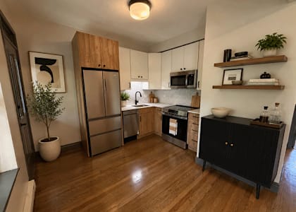 A kitchen with wooden floors and a black cabinet.