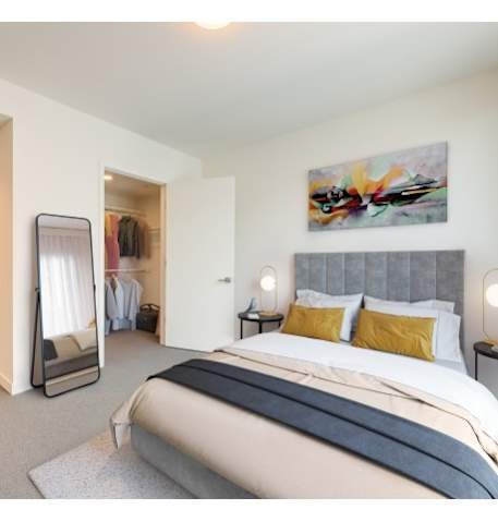 A bedroom with a large bed and a painting on the wall.