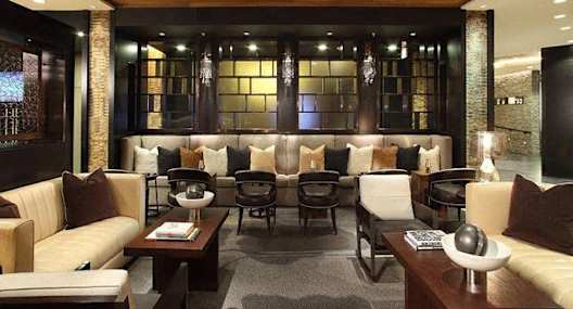 A modern living room with a wooden ceiling and a variety of seating options.