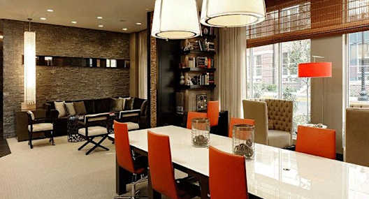 A modern dining room with a long table and chairs.