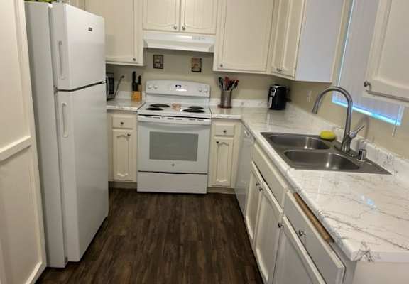 a kitchen with a white stove top oven next to a sink