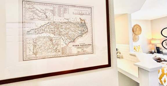 A framed map of the island of Capri is hanging on a wall above a desk.