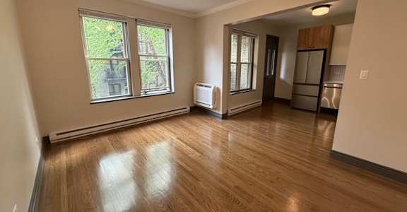 A room with wooden floors and a ceiling fan.