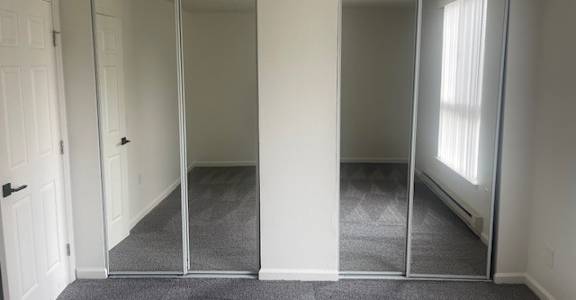 A room with a carpeted floor and a sliding glass door.