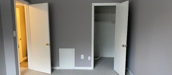 a bedroom with a closet and a door open