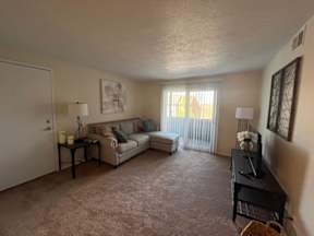 A living room with a couch, a table, and a television.