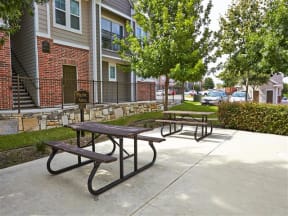 Outdoor courtyard with picnic table seating surrounded by trees