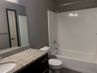 Large bathroom with granite countertops, shower and tub Spacious bathroom with tub shower and granite countertops in 1 bedroom apartment for rent at The Flats at 84 best apartments Lincoln NE 68516
