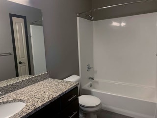 Spacious bathroom with tub shower and granite countertops in 1 bedroom apartment for rent at The Flats at 84 best apartments Lincoln NE 68516