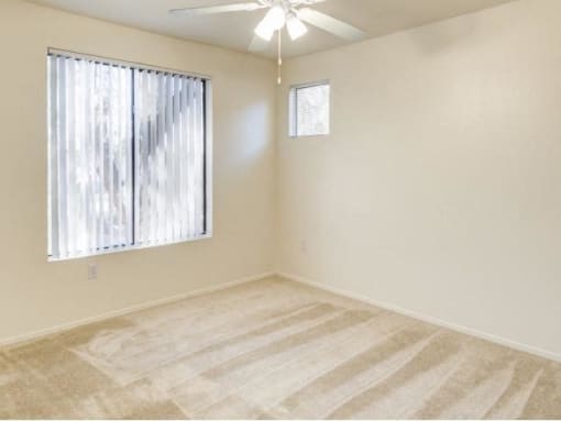 Ingleside Apartments bedroom with wall to wall carpet, a ceiling fan, and large window