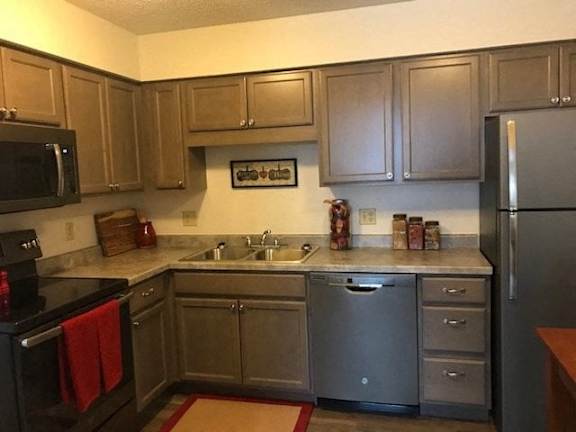 A kitchen with a black oven and a black microwave.