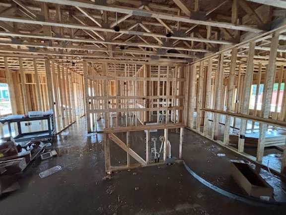 A house under construction with wooden framework and exposed beams.