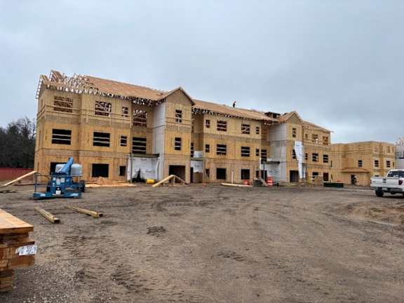 A construction site with a partially built two-story building.