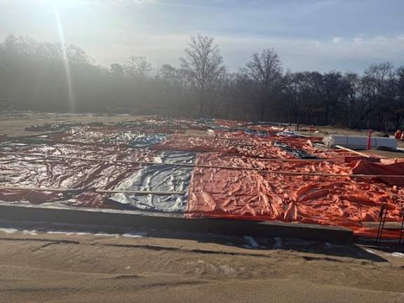 A construction site covered in red and white tarp.