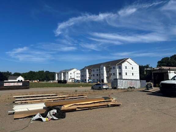 A construction site with a building under construction and a truck parked nearby.
