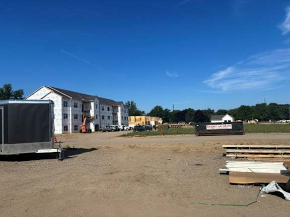 A construction site with a trailer and building materials.