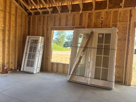 A room under construction with two doors and a window.