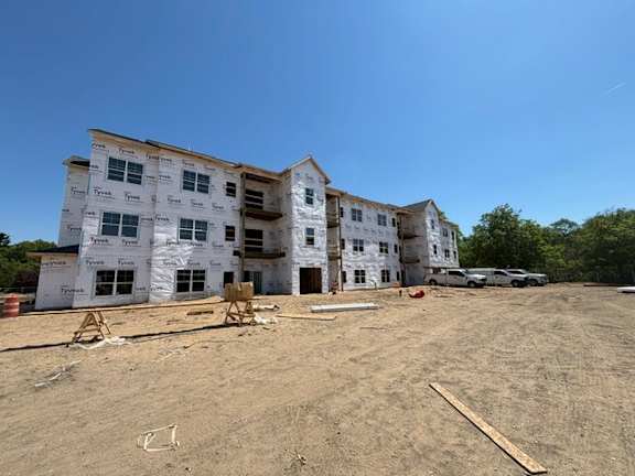 A large white building under construction with a clear blue sky above.