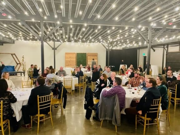 a group of people sitting at tables in a large room