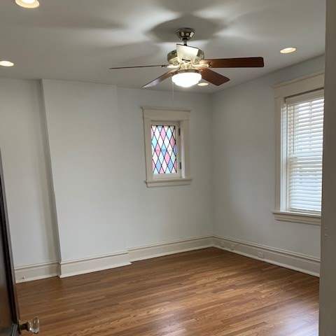 a room with a stained glass window and a ceiling fan
