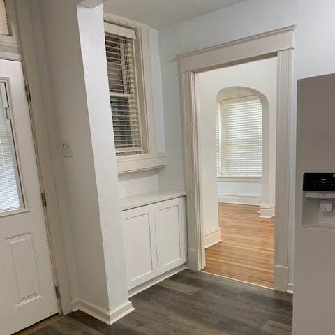 a stairwell with white cabinets and a window